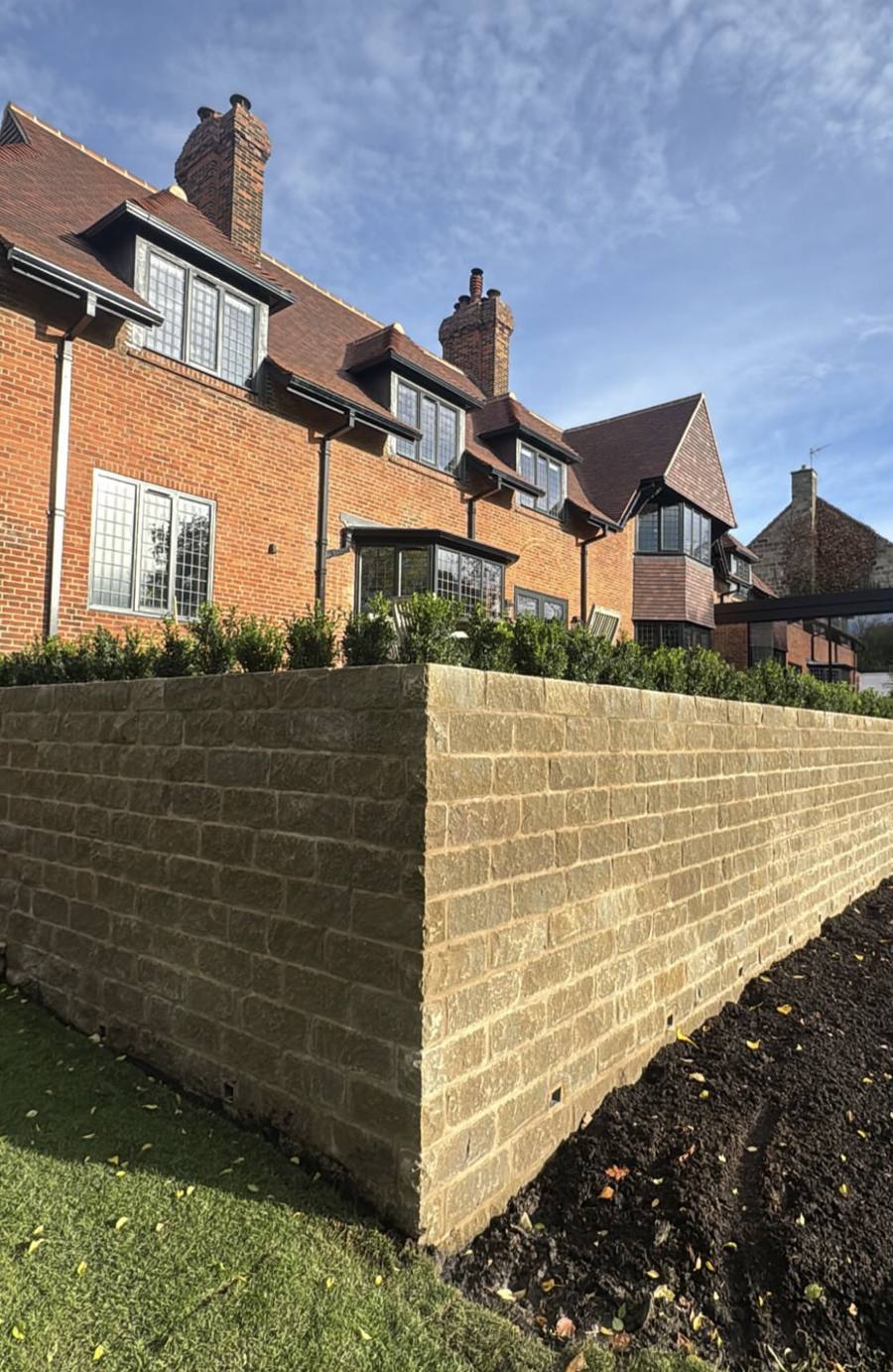 Retaining wall faced in walling stone