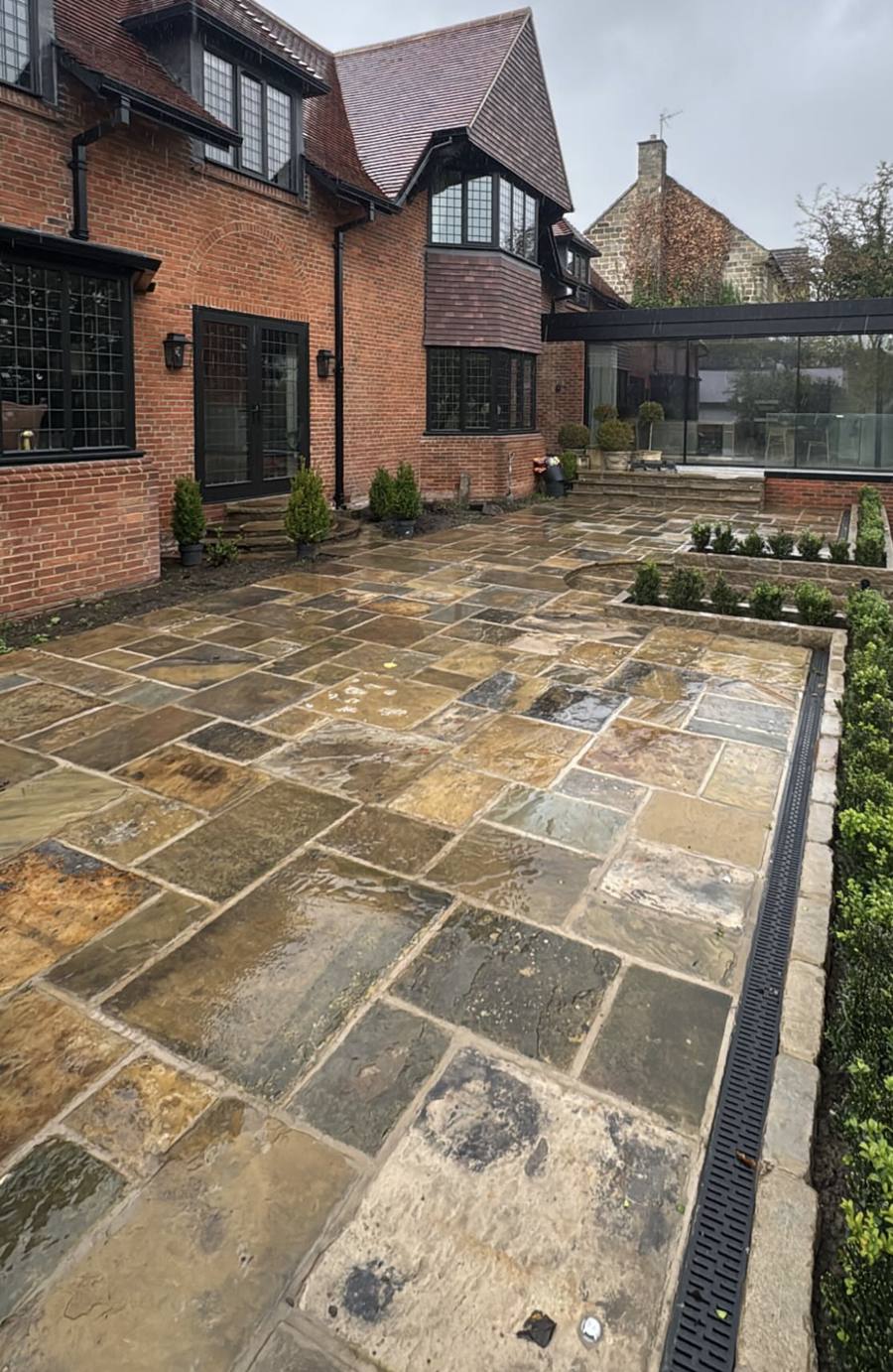 Wet Yorkshire stone patio with a drainage channel