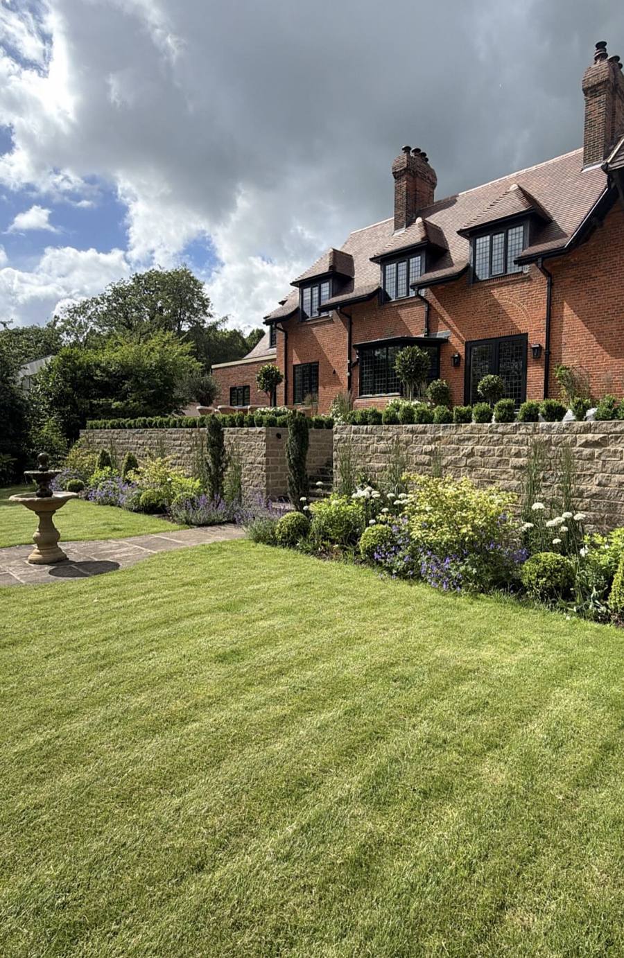 Retaining wall faced in walling stone above a lawn