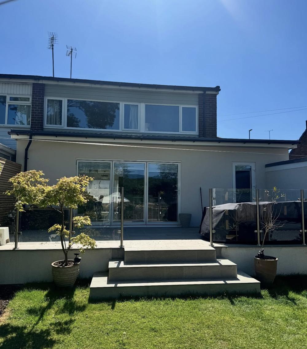 Rendered wrap-around extension with bifold doors and steps to the garden